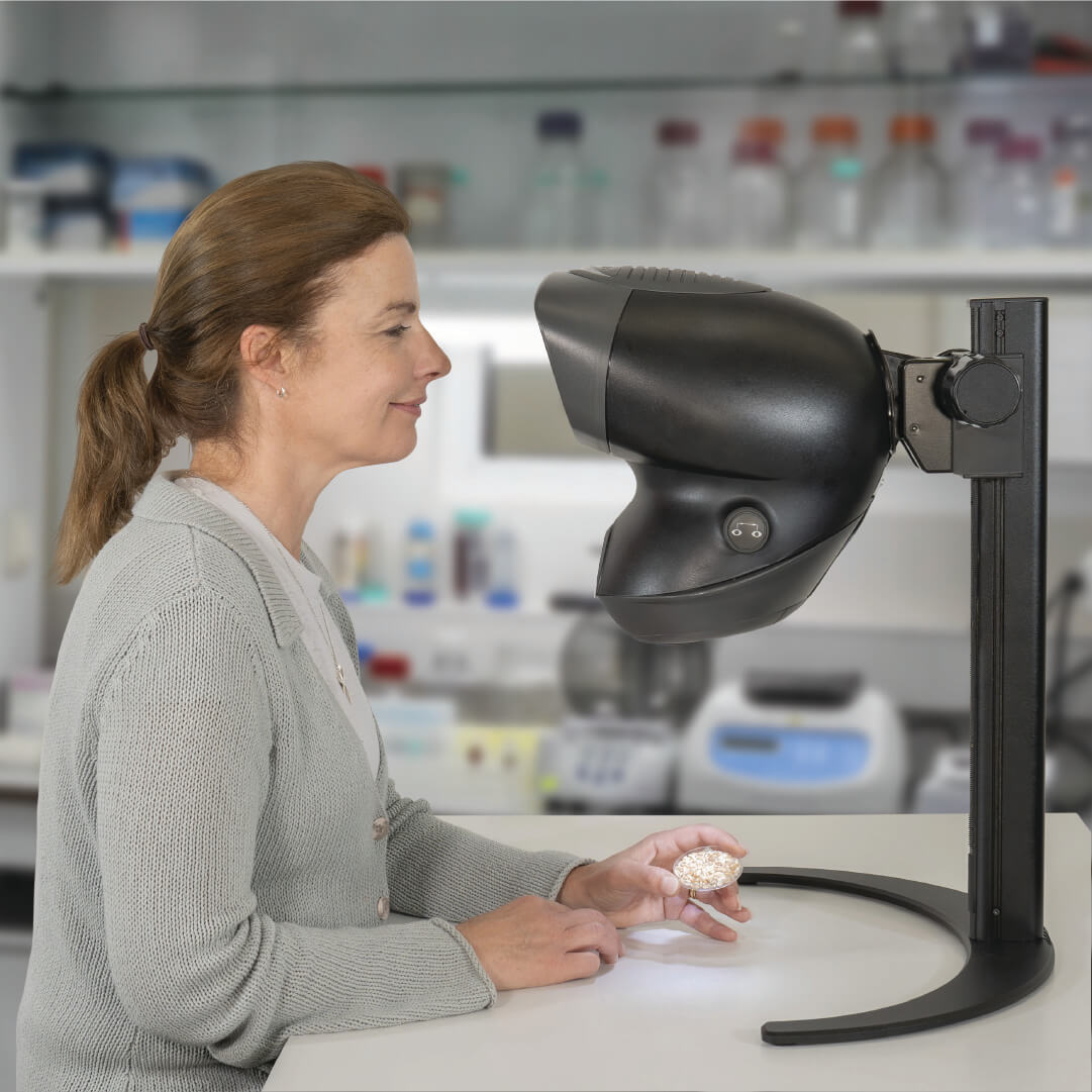 OPTA stereo microscope being using by woman in lab to inspect samples