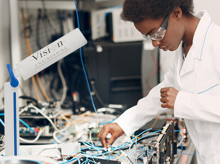 Women wearing safety glasses inspecting system using illumination for Flex2Light task lamp